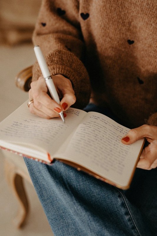 Hand schreibt in ein Notizbuch